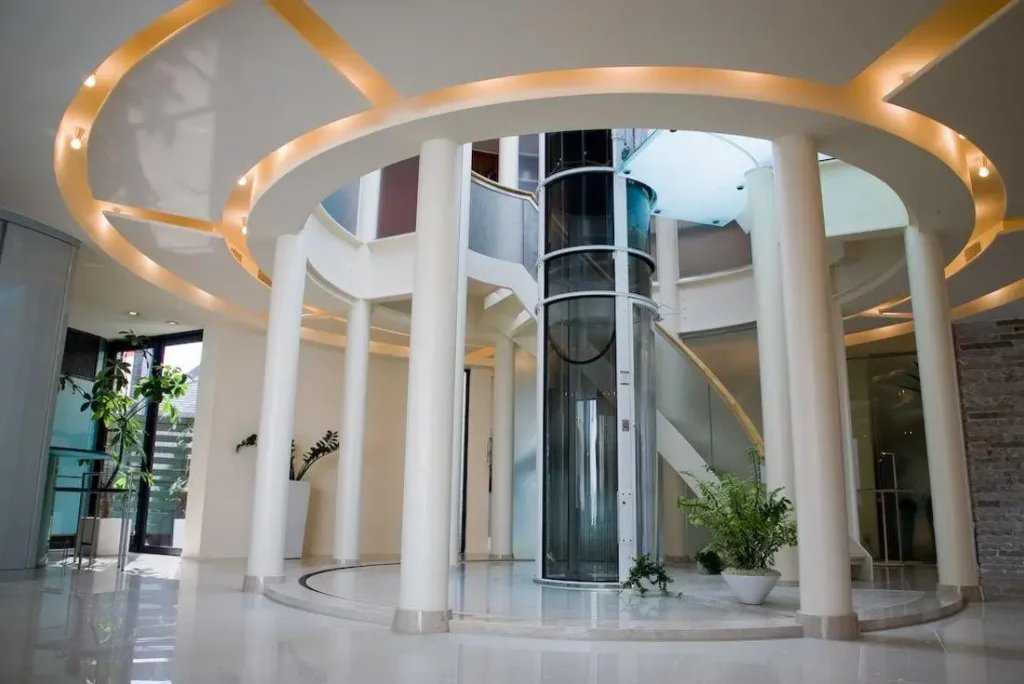 Pneumatic-vacuum-home-elevator-installed-as-the-centerpiece-of-a-modern-atrium-during-new-home-construction-