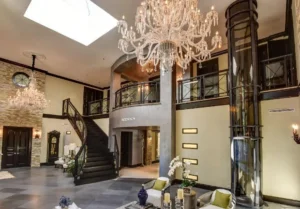 Modern home elevator vs platform lift solution installed beside a staircase in a contemporary residential interior.