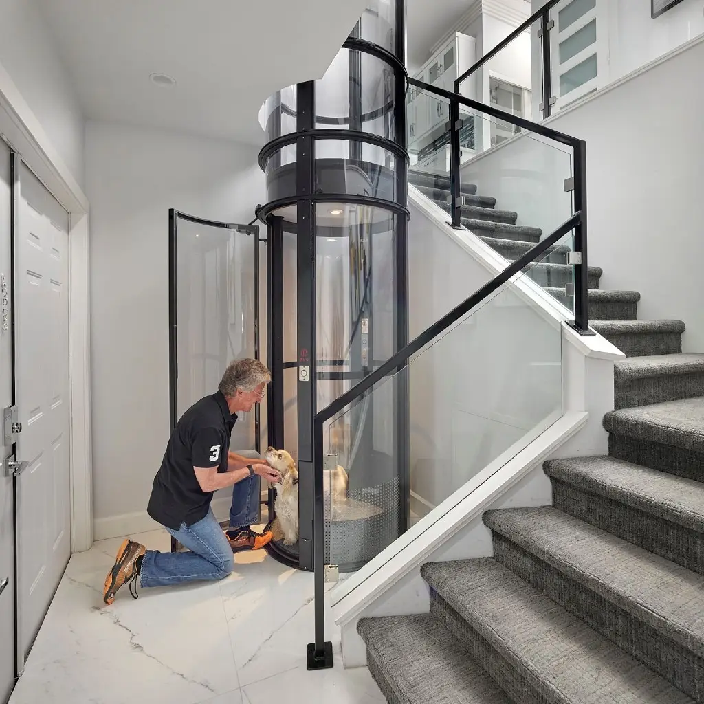 Residential pneumatic elevator installed beside a staircase, providing safe and efficient multi-floor access in an existing home.
