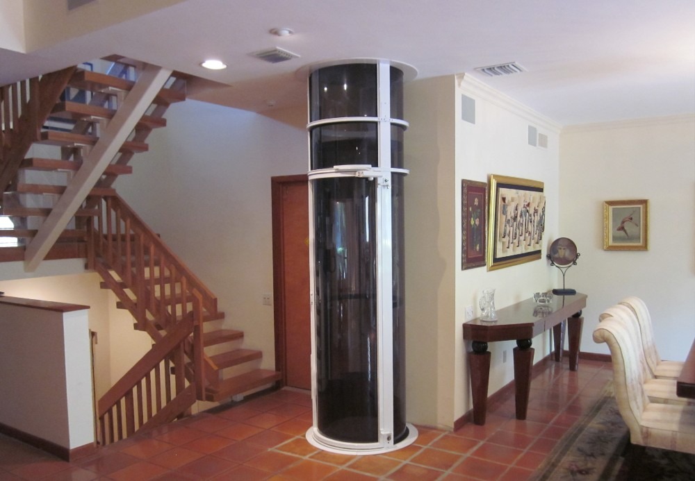 Modern residential home elevator next to a staircase in a private residence
